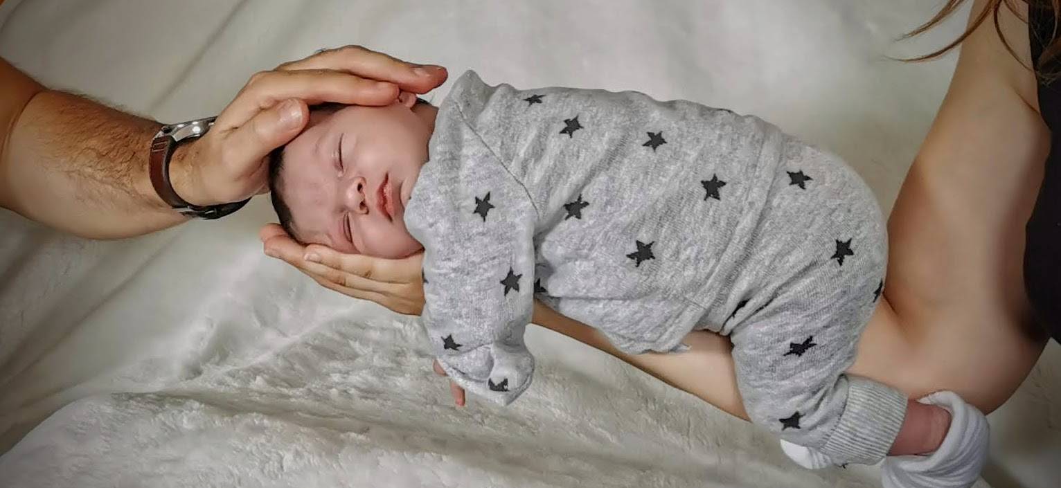 nouveau né tenu dans les mains des deux parents